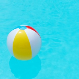 Relax and unwind poolside a yellow and red ball