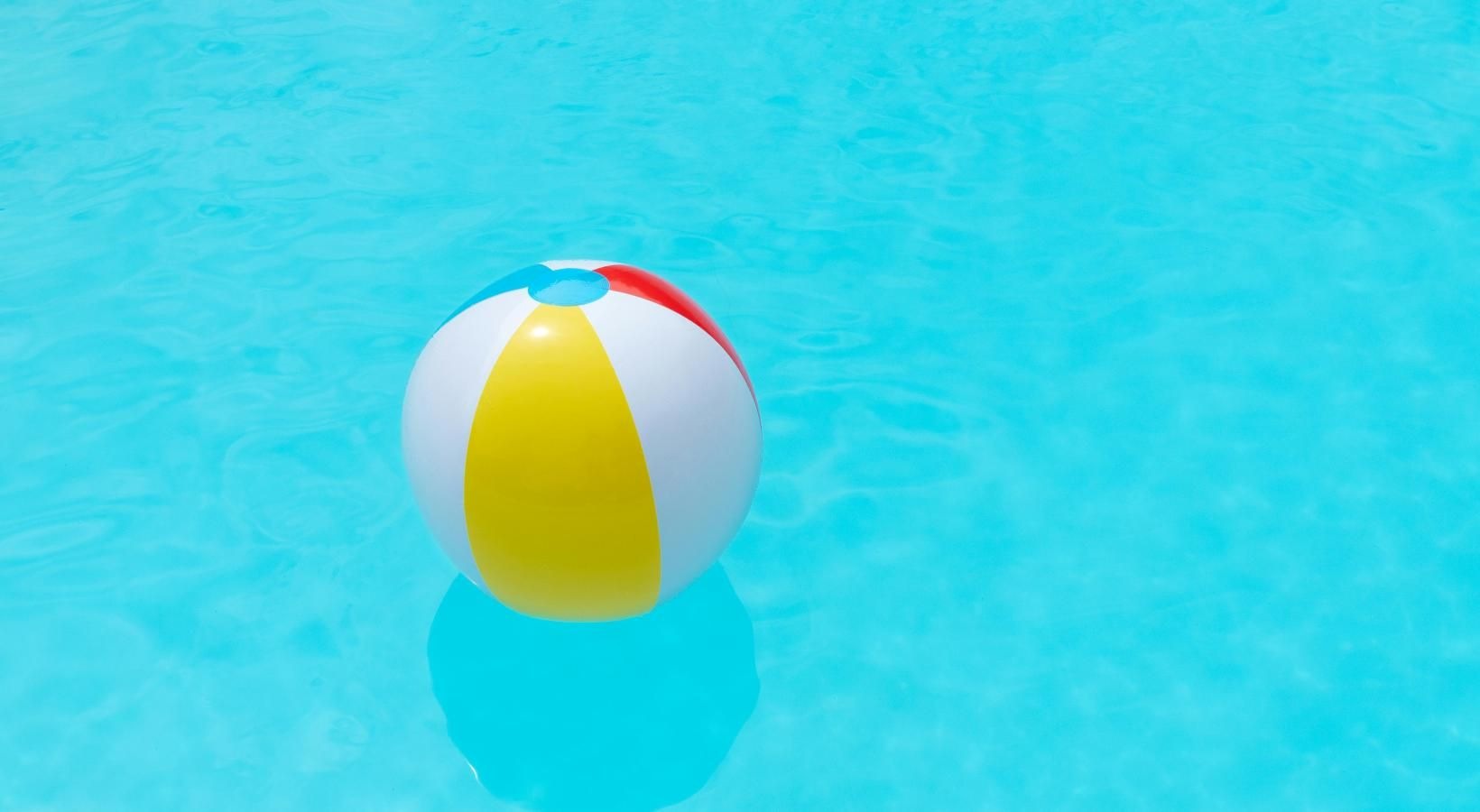 Relax and unwind poolside a yellow and red ball