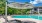 a pool with chairs and a covered area next to it