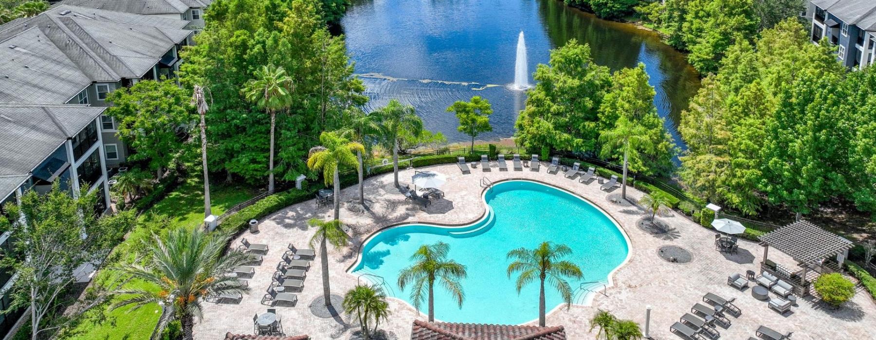 a pool surrounded by trees and buildings