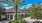 a building with a large palm tree and landscaping